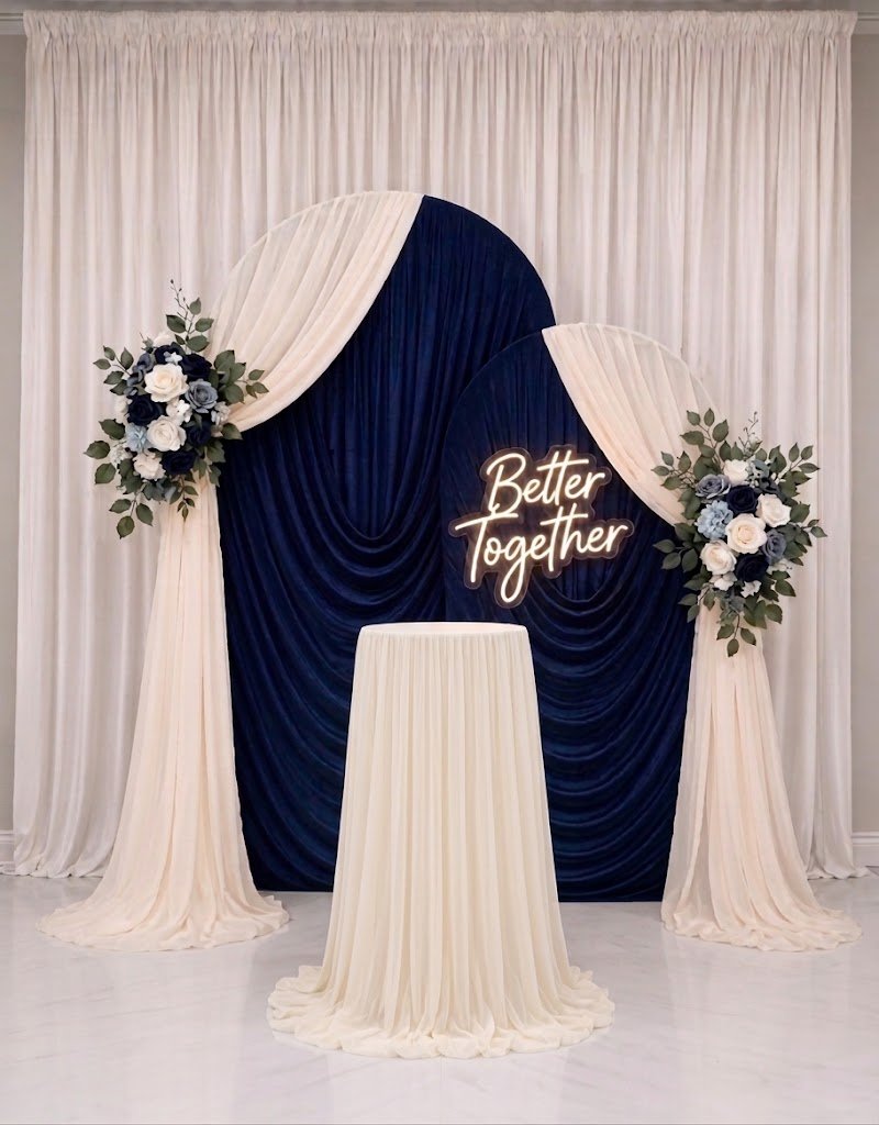 Navy and ivory draped arches with white flowers and a Better Together sign