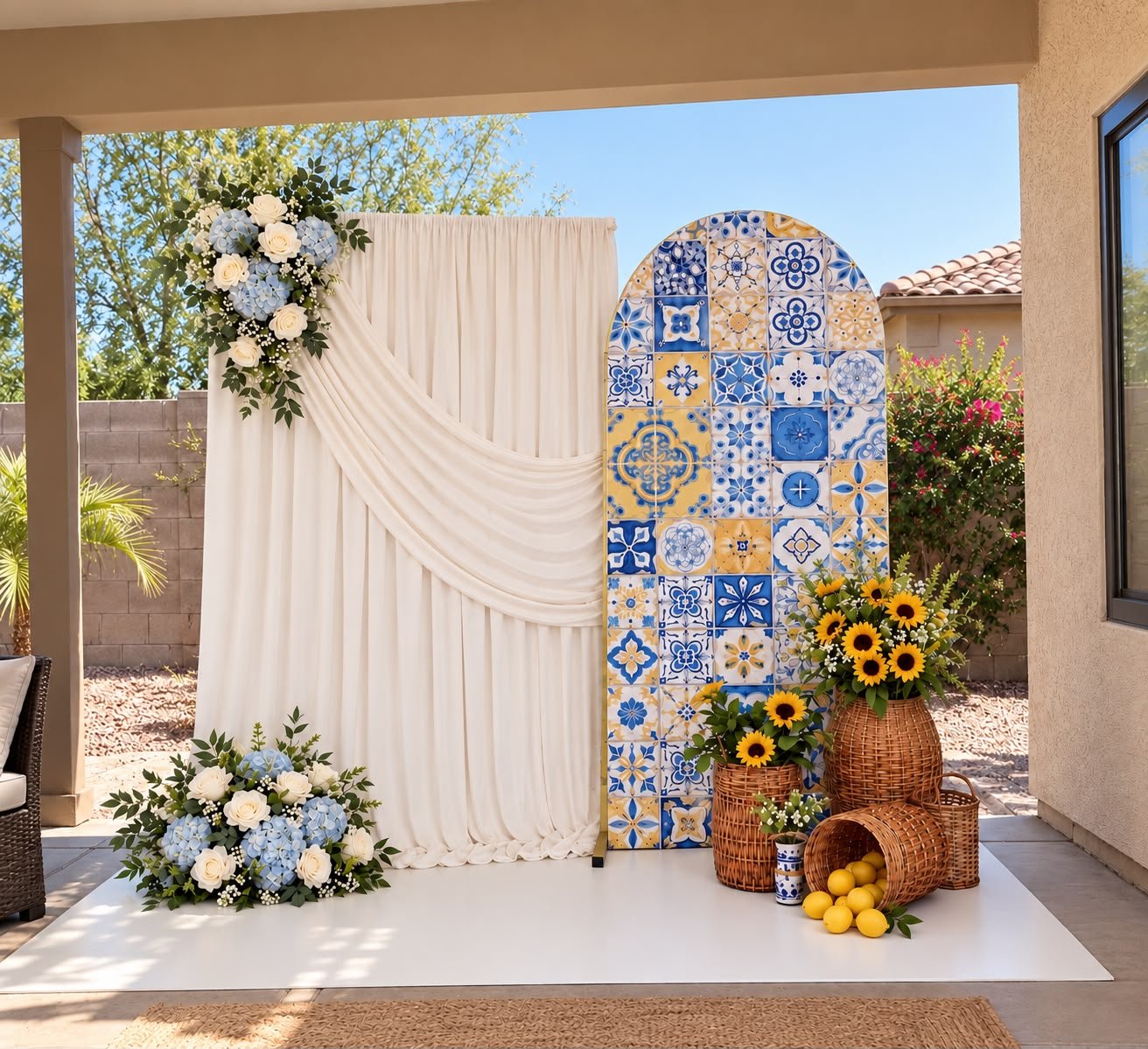 Ivory draping beside a blue and yellow tile-patterned arch with flowers and lemons