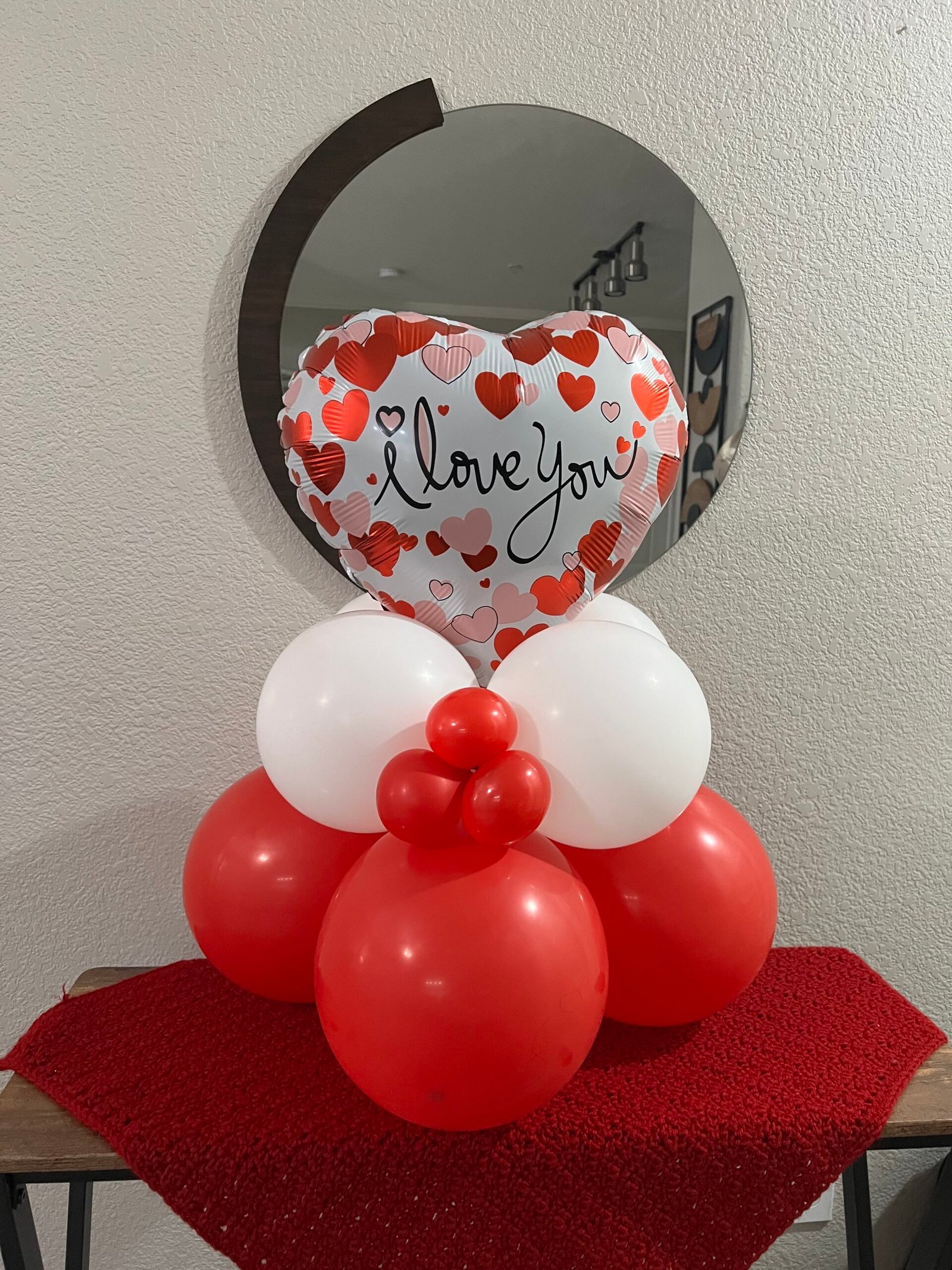 Valentine heart balloon above red, pink and white balloon clusters