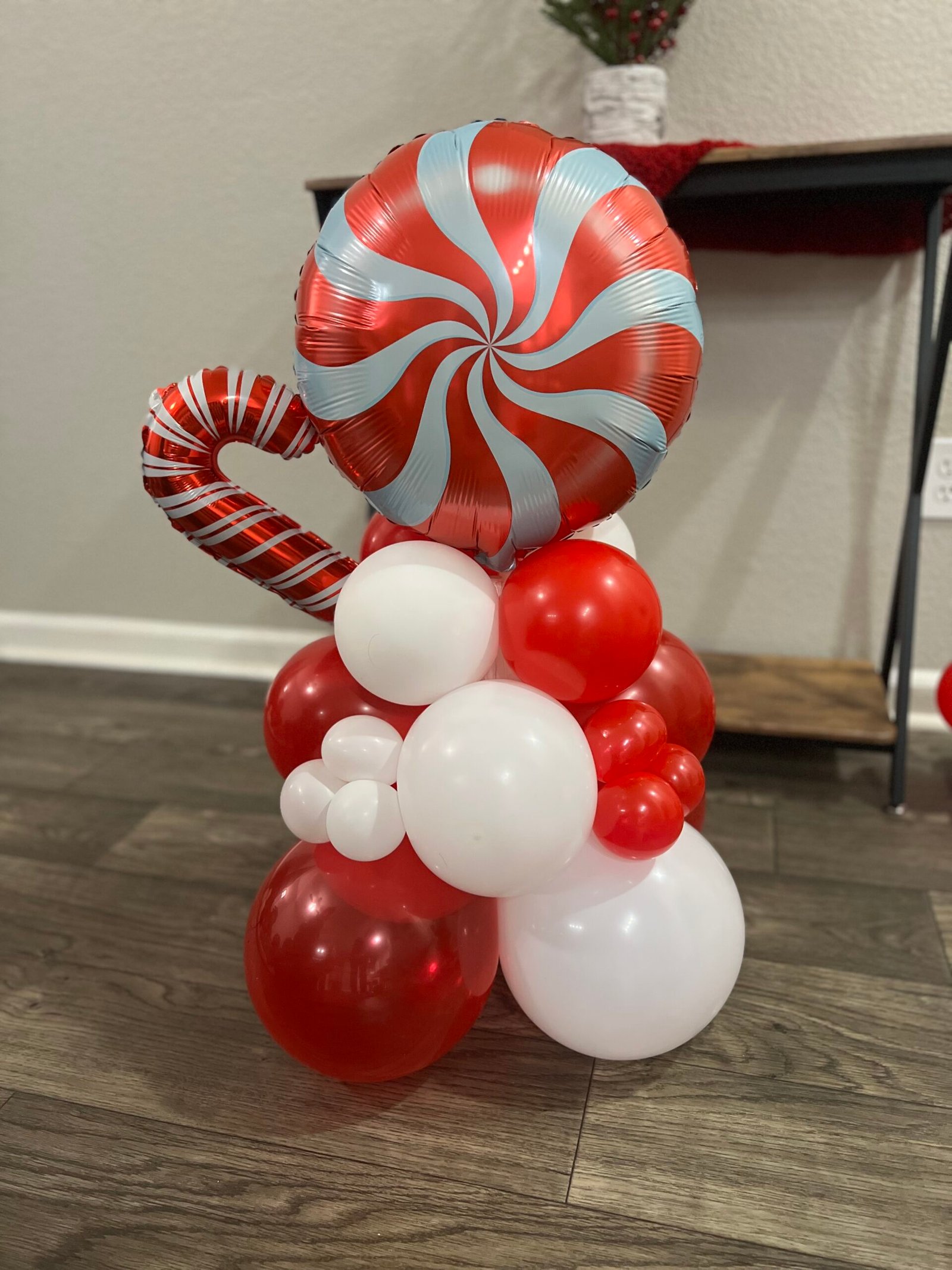 Red and white peppermint balloon display with candy cane details