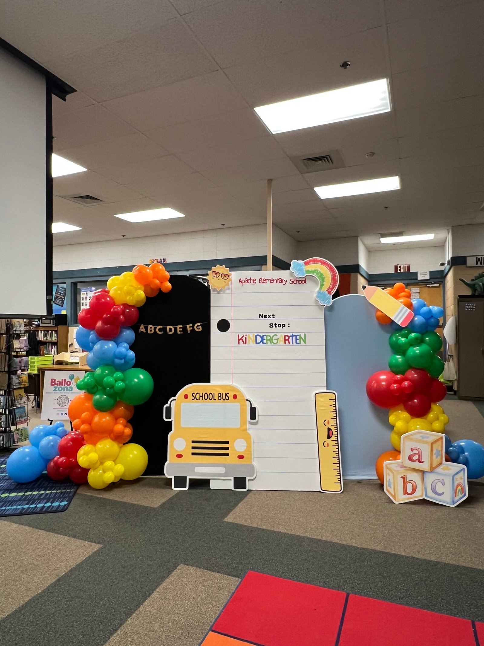 Colorful balloon garlands around a school celebration backdrop