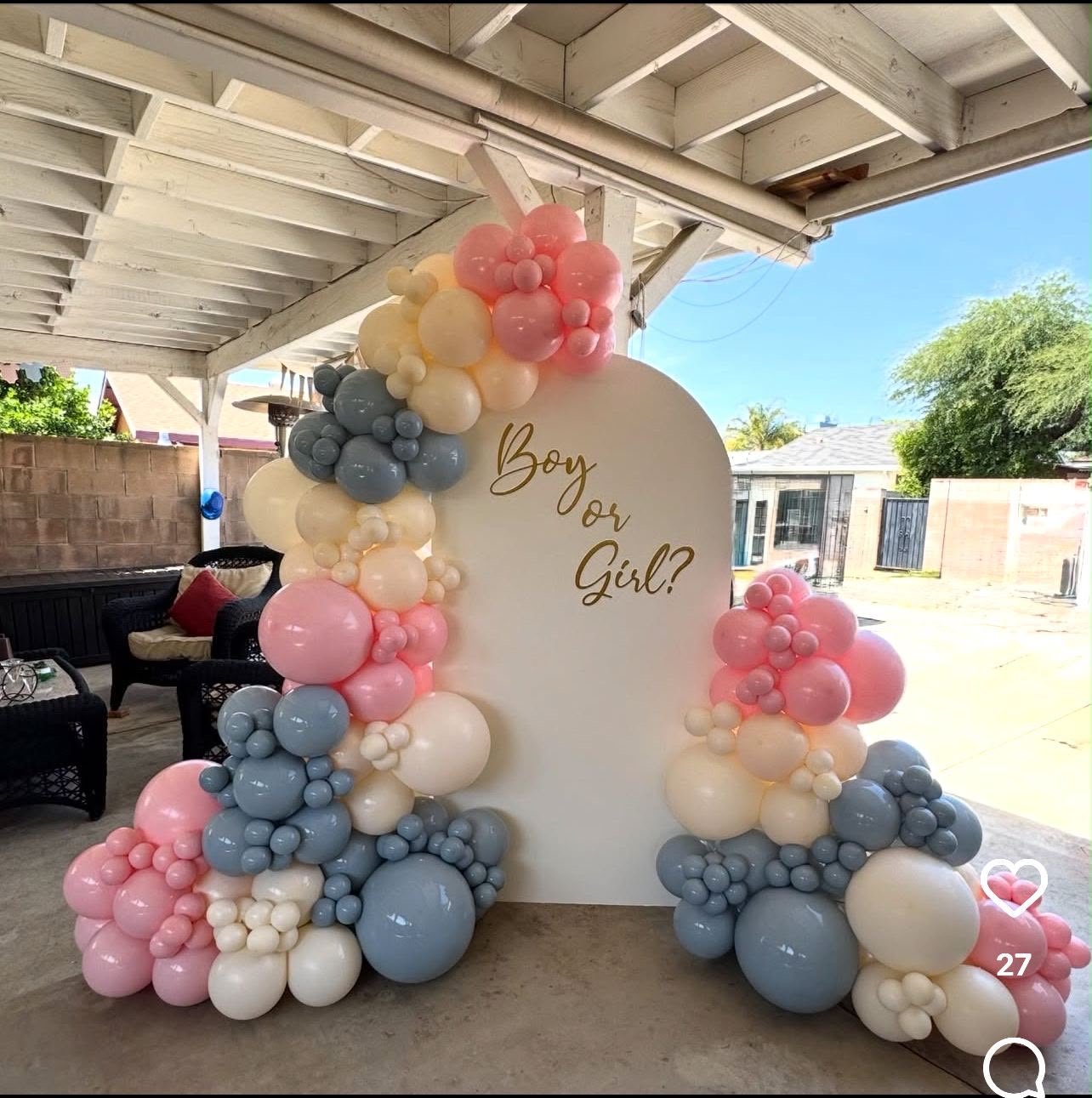 Pink and cream balloons with flowers framing a baby girl celebration backdrop